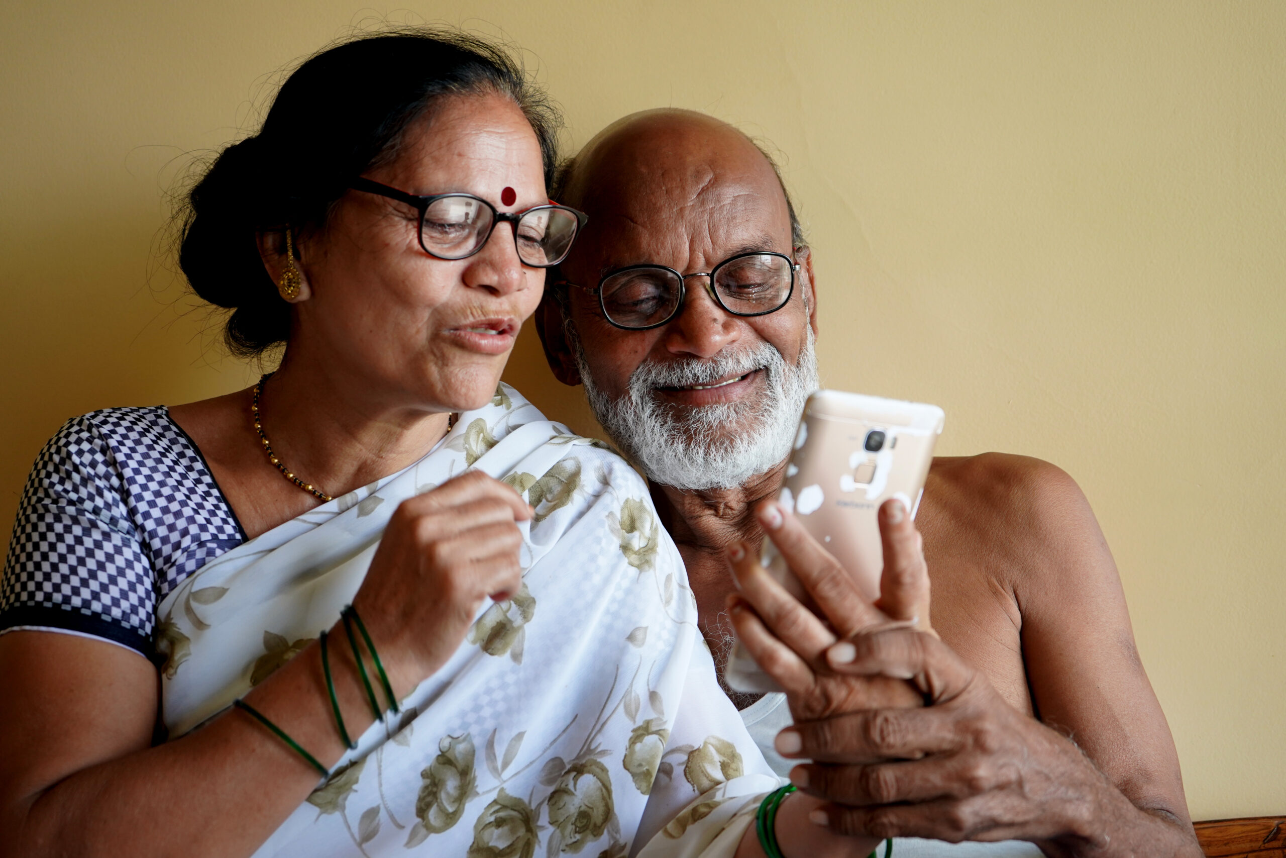 Indian senior couple video chatting on phone at home, Technology connect and modern elderly lifestyle concept.