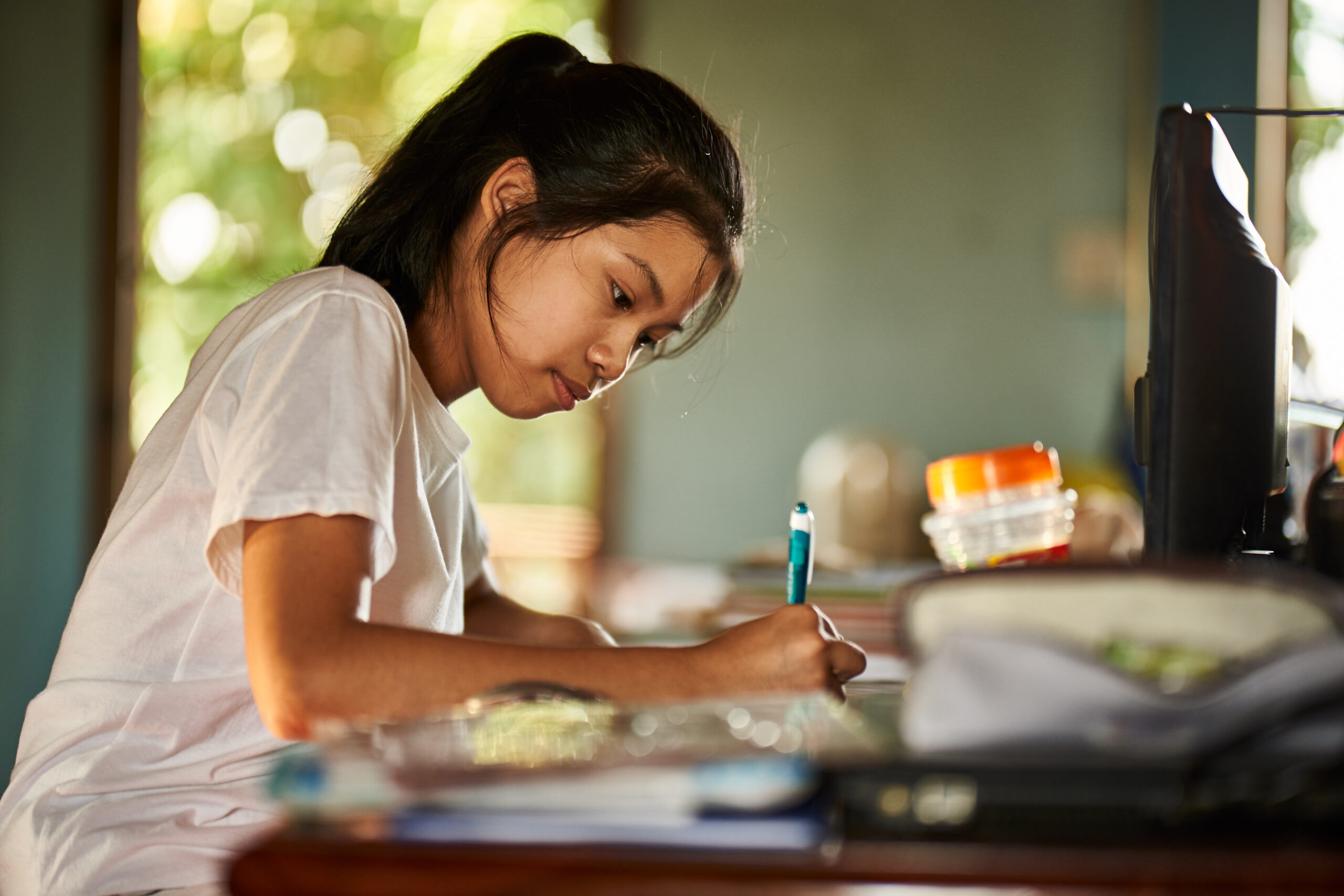 thai teen girl doing homework and studying at home