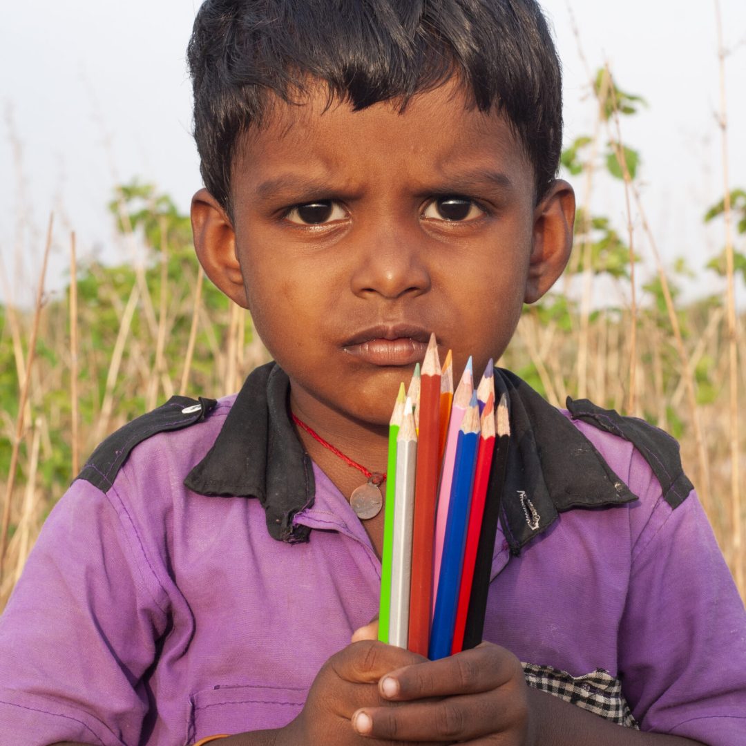 Boy holding with colorful pencils.